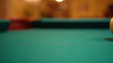 Slow-Motion-Billiards-solid-black-8-ball-shot-in-corner-pocket-on-pool-table-with-green-felt-and-brown-pockets-with-the-cue-ball-sliding-out-of-frame-Low-Angle-Close-Up-with-Red-Spinning-Dots