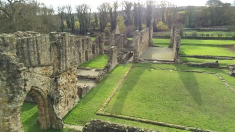 Basingwerk-abbey-landmark-medieval-abandoned-Welsh-ruins-Aerial-view-slow-close-pull-away-orbit-right