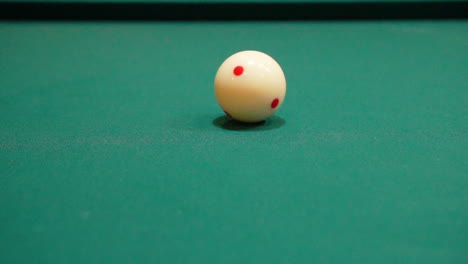 Slow-Motion-Billiards-Person-takes-Practice-or-Warmup-Strokes-on-Pool-Table-with-Green-Felt-using-Cue-Stick-and-addressing-the-Cue-Ball-with-3-Red-Dots-or-Spots-Close-Up