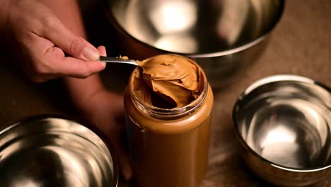 Scooping-Peanut-Butter-With-Metal-Spoon