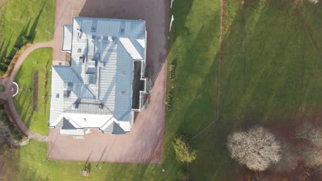 Roof-of-Luxurious-Mansion-in-Green-Open-Garden,-Aerial-Top-Down-Shot