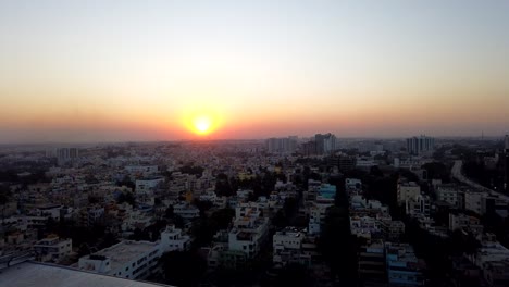 Zeitraffer-Des-Sonnenuntergangs-über-Der-Stadt-Bangalore-Mit-Wenigen-Wolken-Am-Himmel-Und-Orangefarbenen-Knickententönen