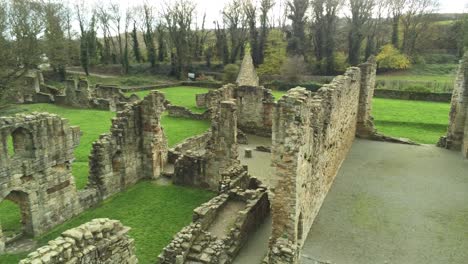 Basingwerk-abbey-landmark-medieval-abandoned-Welsh-ruins-Aerial-view-closeup-pan-right