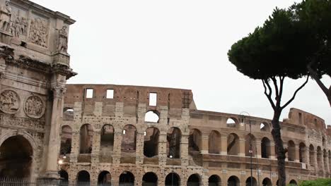 Arco-De-Constantino-Y-El-Coliseo,-Monumentos-De-La-Ciudad-Antigua,-Panorámica,-Vista-En-Un-Día-Lluvioso,-Roma,-Italia