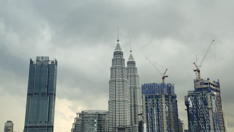 Petronas-Twin-Towers,construction-cranes,Kuala-Lumpur,Malaysia,cloudy