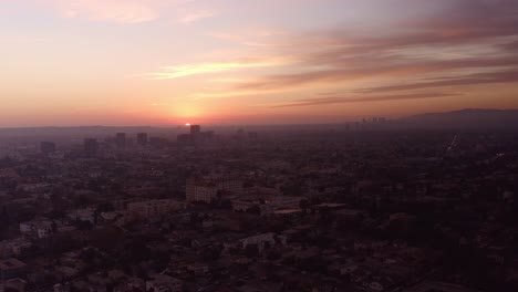 Wide-aerial-shot-of-the-sun-disappearing-over-the-horizon-in-the-city-of-Los-Angeles