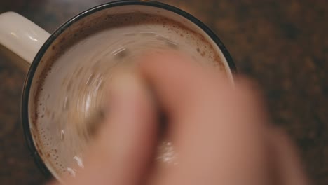 Hand-Mixing-A-Mug-Of-Hot-Chocolate-Drink-Using-Spoon---Static,-High-Angle-Shot