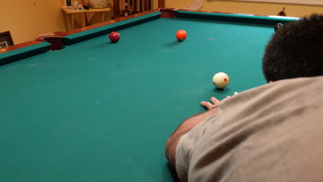 Man-Playing-8-Ball-Pool-Shoots-Solid-Orange-5-Ball-into-Corner-Pocket-on-a-Brunswick-Table-with-Green-Felt-and-Two-Balls-on-the-Table,-Open-Bridge-Hand-and-Wooden-Cue-Stick,-No-Faces-Perspective-Angle