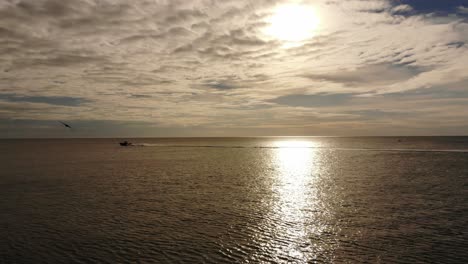 Dramatischer-Ozean:-Rennschnellboot-Mit-Möwe-Und-Geisterhaftem-Sonnenball-Zwischen-Flauschigen-Wolken-Am-Nachmittag