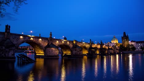 Day-to-night-sunset-timelapse-as-the-Charles-Bridge-in-Prague,-Czech-Republic-lights-up-during-the-evening-with-a-view-of-the-Old-Town-bridge-Tower