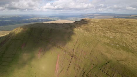 Cloud-shadows-passing-over-Brecon-Beacons-Llyn-y-Fan-Fach-green-mountain-wilderness-rising-aerial-shot