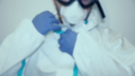 Cropped-Portrait-Of-Medical-Worker-Putting-On-Hood-Of-PPE-Suit---Coronavirus-Concept---medium-shot