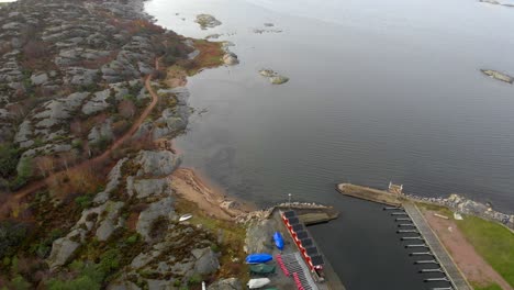 Aerial-view-of-sea-coast-with-rocky-shore-and-small-dock-and-empty-berths