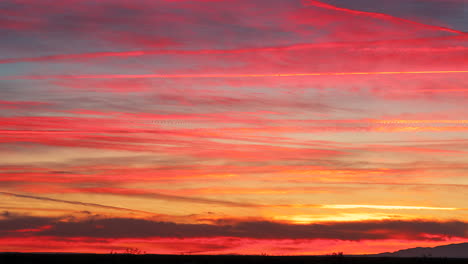 Breathtaking-Fire-Sunset-with-Vibrant-Red,-Pink-and-Orange-Light-on-Wispy-Clouds