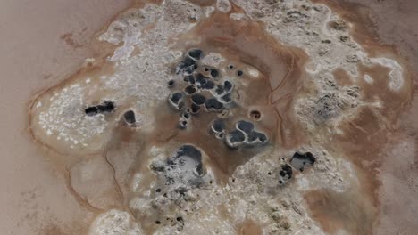 Group-of-mud-fumaroles-in-barren-surface-of-Namaskard-in-Iceland,-aerial
