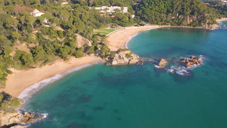 aerial-image-with-drone-of-lloret-de-mar-virgin-beach-with-green-vegetation-in-mediterranean-sea-in-the-mediterranean-santa-cristina-lloret-de-mar-spain-europe