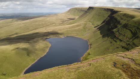 Vast-trekking-Llyn-y-fan-Fach-mountain-range-Brecon-beacons-aerial-view-reveal-idyllic-blue-lake