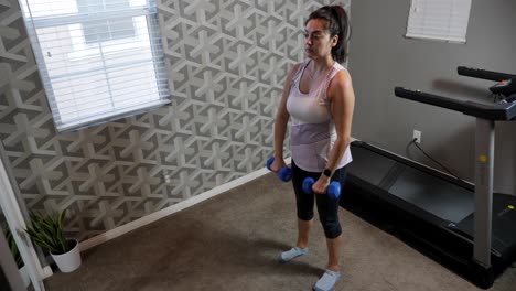 Overhead-view-of-hispanic-female-working-out,-lifting-weights-in-room-with-treadmill