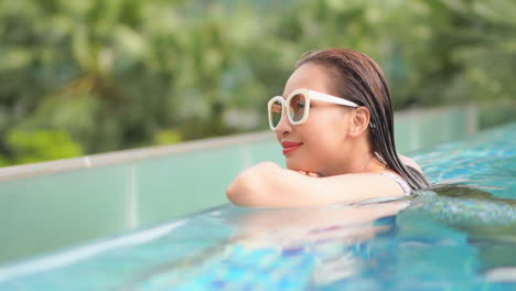 Nahaufnahme-Einer-Asiatischen-Frau-Mit-Sonnenbrille,-Die-Sich-Allein-Im-Pool-Entspannt