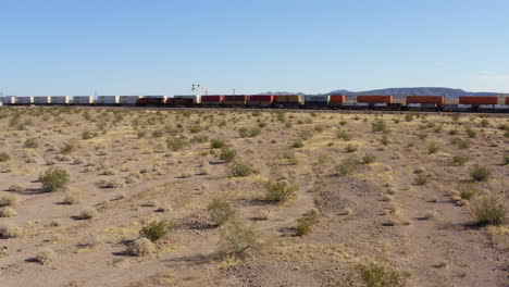 Zwei-Lange-Güterzüge,-Die-Aneinander-Vorbeifahren,-Fahren-In-Der-Wüste-Von-Kalifornien-In-Entgegengesetzte-Richtungen