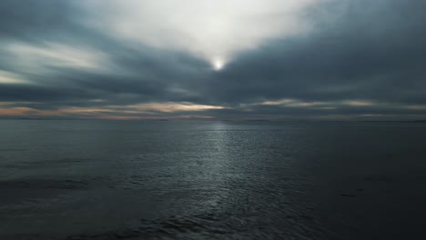 Aerial-view-of-dark-cloudy-day-at-sea-moving-backwards