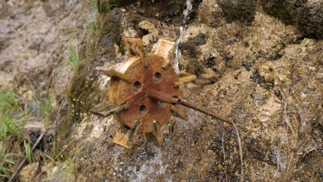 Small-wooden-water-mill-spinning-under-dripping-water