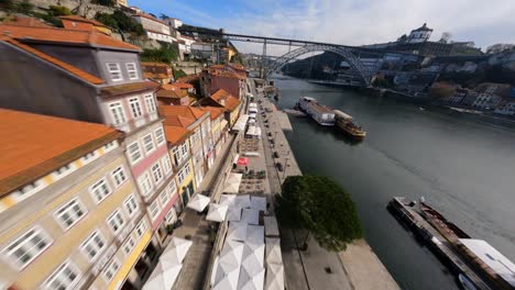Rote-Dächer-Zoomen-Vorbei-über-Flussseite-Fpv-Drohne-Dom-Luis-Brücke-Porto-Portugal
