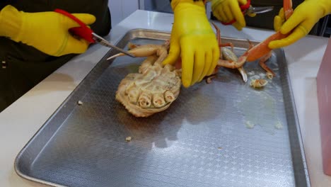 Cutting-Legs-Of-Cooked-King-Crab-On-Tray-By-Scissors