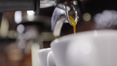 Primer-Plano-De-Espresso-Que-Fluye-En-Dos-Tazas-De-Espresso