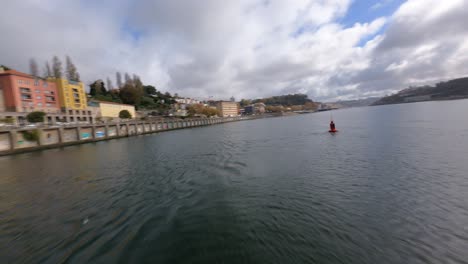 Circle-around-a-orange-buoy-in-a-blue-water-lake-FPV-drone-orbit-Arrabida-Bridge