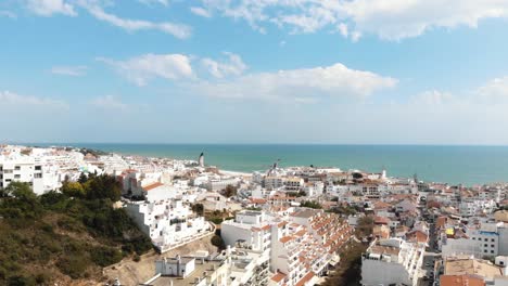 Sea-view-and-white-cityscape-of-Albufeira,-In-Algarve,-Portugal---Wide-Reveal-Aerial-Shot