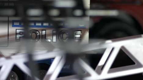 Police-car-at-crime-scene,-View-Through-Fence-Panning-Shot
