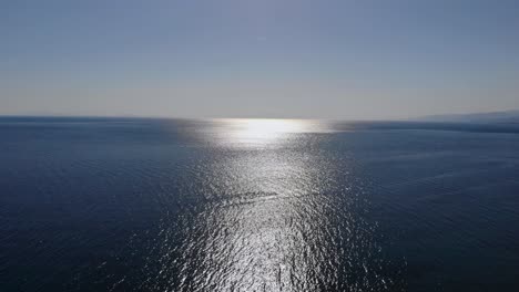 Aerial-upward-flight-over-Marmara-Sea-when-sunlights-touch-on-sea-surface,-Balikesir,-Turkey