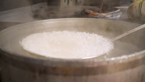 Strainer-skimmer-scoops-freshly-boiled-white-basmati-rice,-slow-motion-HD