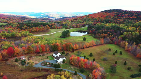 Aerial-View-of-Serene-Autumn-Landscape,-Multicolored-Forest-and-a-Ranch-in-Rural-Countryside,-Drone-Shot