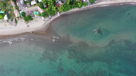 Aerial-view-of-a-little-town-with-sea-in-Negros-Oriental,-Philippines,-during-a-sunny-day