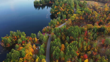 Drone-Aerial-View-of-Road-at-Scenic-Lakeside-and-Vivid-Forest-in-Autumn-Colors
