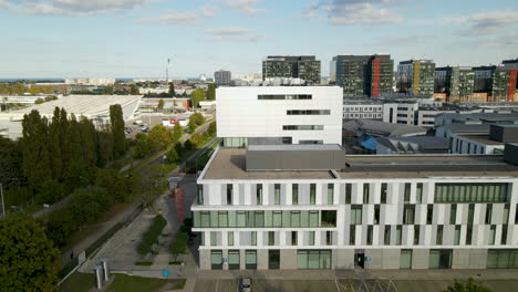 Aerial-drone-orbit-around-sunny-modern-university-city-building-in-Poland