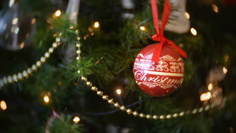 A-decorated-Christmas-tree-had-a-red-bauble-displaying-the-words---Merry-Christmas