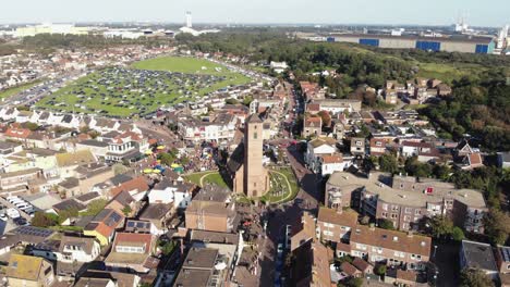 Aerial-4k-drone-footage,-panning-the-horizon-of-the-small-coastal-town-of-Wijk-aan-Zee-in-North-Holland,-the-Netherlands