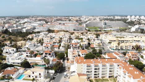 Aerial-4k-drone-footage-panning-the-horizon,-revealing-the-European-popular-coastal-resort-town-of-Albufeira,-Portugal