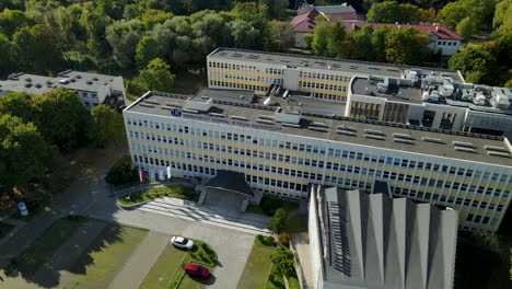 Aerial-wide-angle-orbit-around-sunny-European-university-building-among-trees