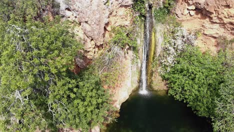 Aerial-4k-drone-footage-of-a-waterfall-in-Alte,-Portugal-on-a-bright-day