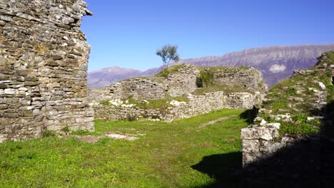 Ruined-stone-walls-of-medieval-castle-with-mountain-background-on-a-sunny-day
