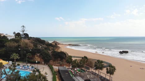 Luxury-Sea-View-over-beachside-hotel-and-mediterranean-shore-in-Albufeira,-Algarve,-Portugal---Reveal-Fly-over-shot