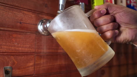 Bartender-pours-beer-from-tap,-hand-pulls-draft-into-frosted-mug,-slow-motion-slider----4K