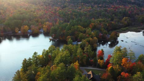 Serene-Autumn-Scenery-at-Lakeside-in-Countryside-of-Vermont-USA,-Aerial-View-of-Colorful-Forest-and-Calm-Water-on-Sunny-Day