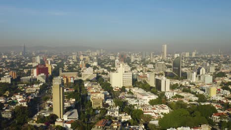Drone-Vuela-Hacia-Atrás-Lejos-De-Edificios-Altos-En-Guadalajara,-México