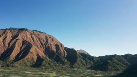 Pergasingan-hill-on-perfect-sunny-day-with-clear-blue-sky-in-Lombok,-aerial
