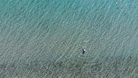Aerial:-Man-swims-from-the-sea-to-the-shore,-Turkey